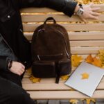 a person reading a book on a bench