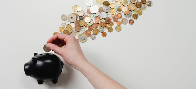 A person putting money inside a piggy bank