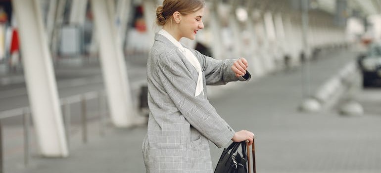 A woman looking at a watch at a bus station