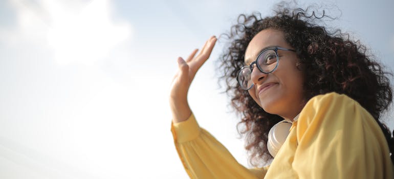 woman waving to neighbors after reading about adapting to your new neighborhood