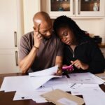 a couple sitting and budgeting for an international move