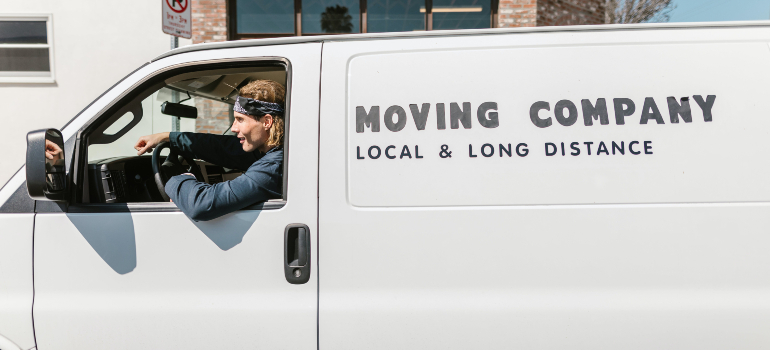A smiling driver in a moving company van ready for local and long-distance moves.