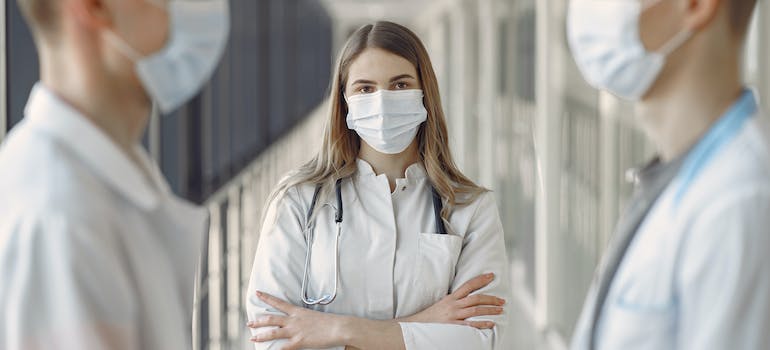 woman in white coat wearing face mask