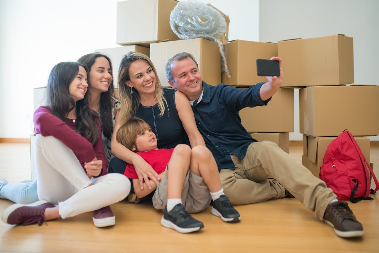 family in front of the packed boxes taking a selfi