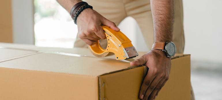 person taping a box for moving from Arizona to Utah