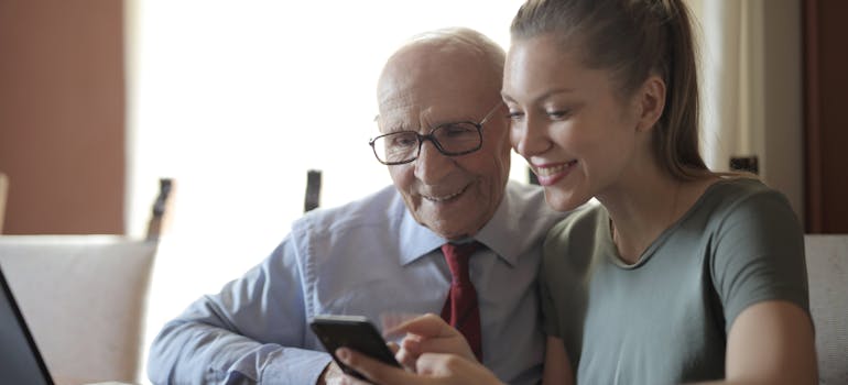 woman and old man looking at smartphone