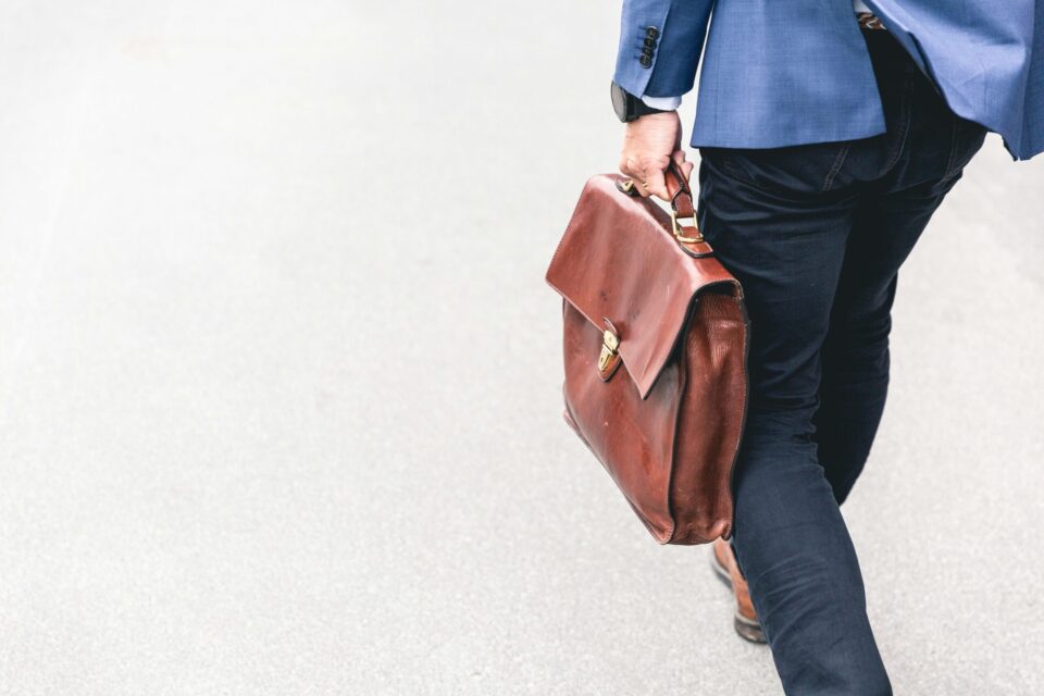 Man walking and carrying a leather bag