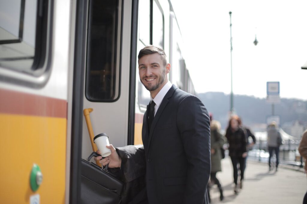 man holding a cup of coffee and standing near the bus