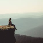 woman sitting on edge of rock after moving from Virginia to Arkansas
