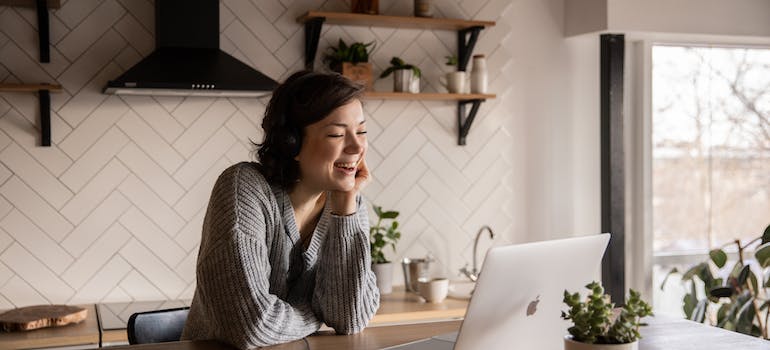 woman smiling and looking at her laptop