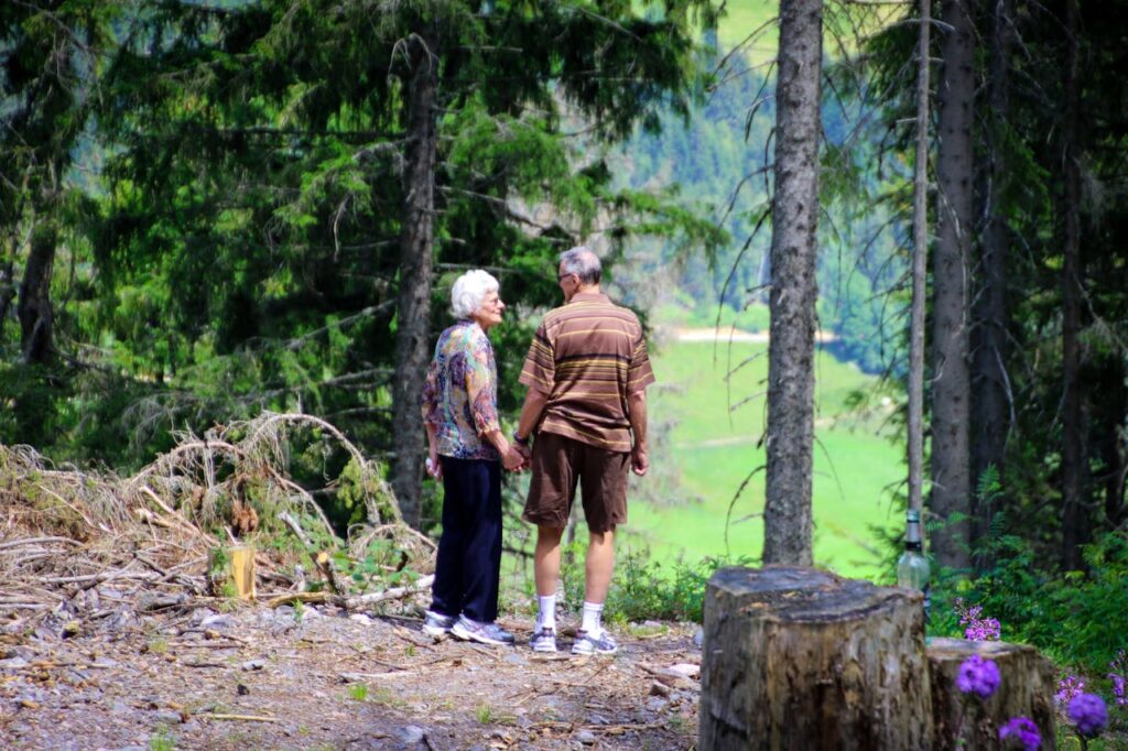 elderly couple standing at forest