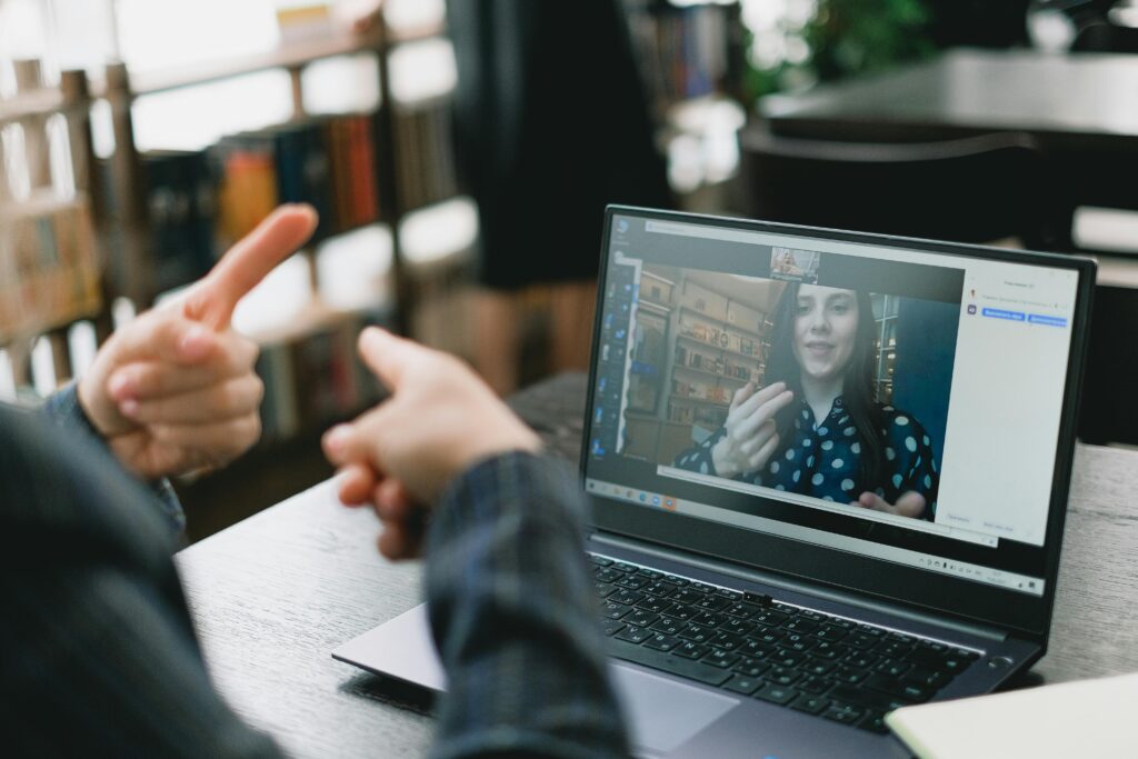 Two people talking through a video call and using their hands to communicate