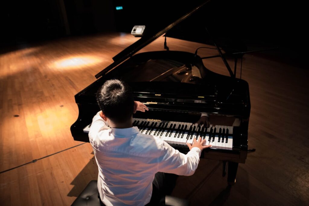 a man in white shirt playing the piano