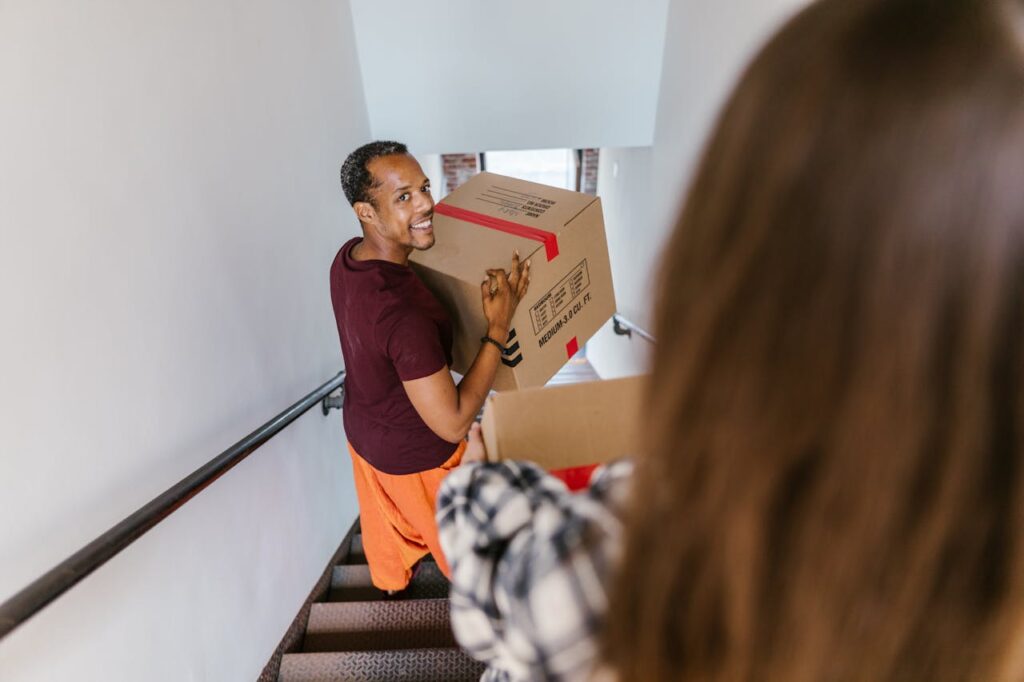 man carrying a box and going down the stairs