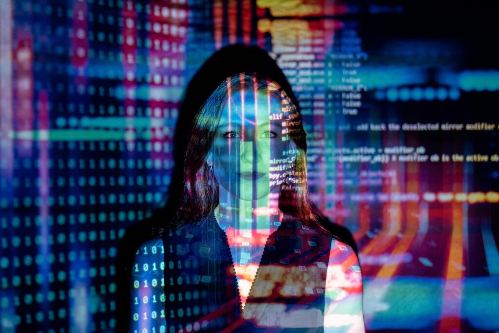 Woman standing behind lights and code projections