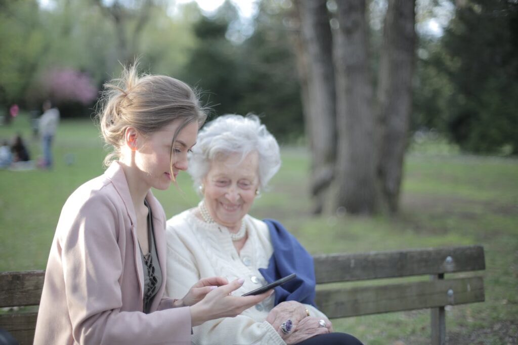 old and young women looking at smartphone
