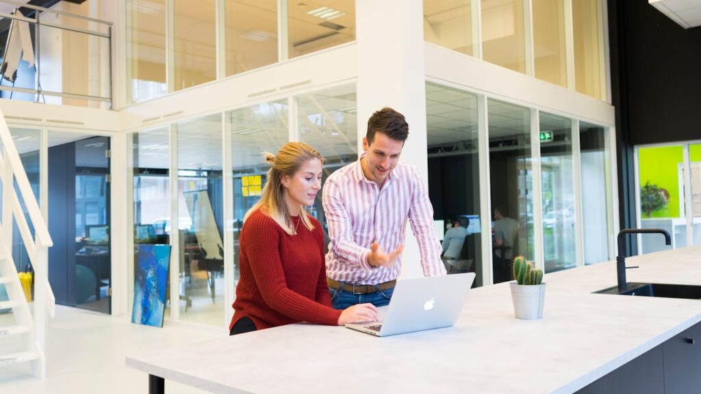 man and woman in an office looking at laptop and reading about the appeal of Nashville