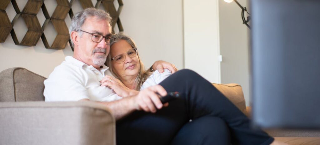 an elderly couple watching tv