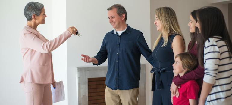 real estate agent giving keys to a family