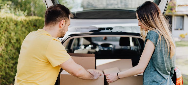 a couple putting boxes into a car