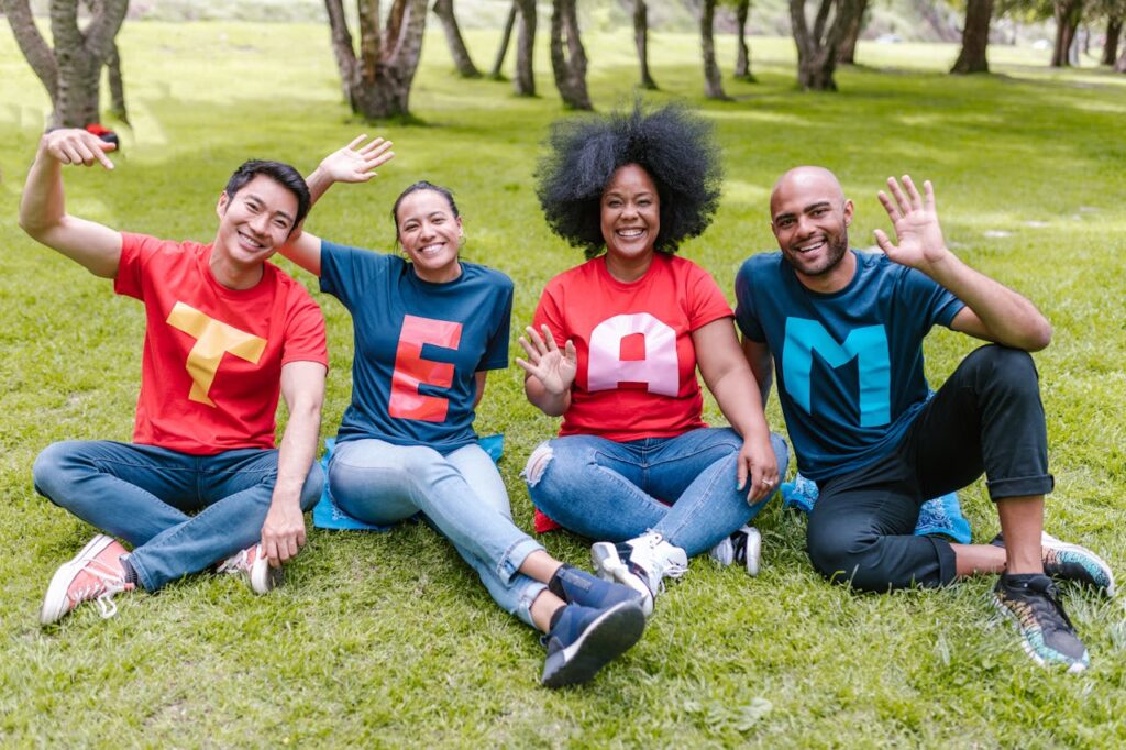four people sitting on a green grass