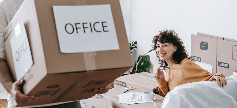 person holding a big box and a woman looking at him