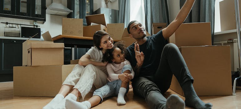 family sitting on floor near boxes