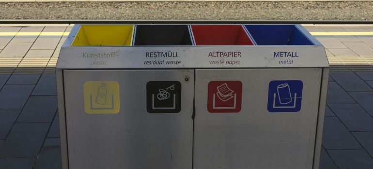 Public recycling station with separate bins for different types of waste to help you answer the question: 
