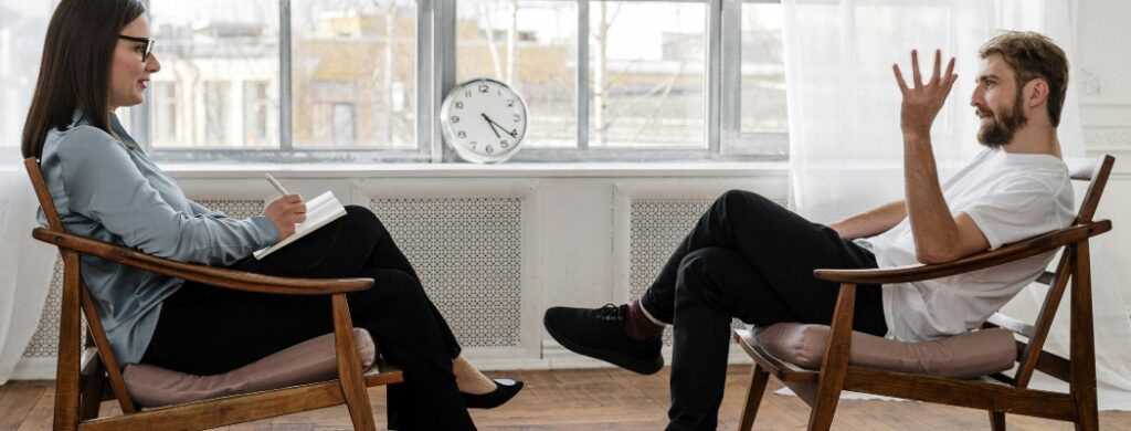 man and woman sitting and talking