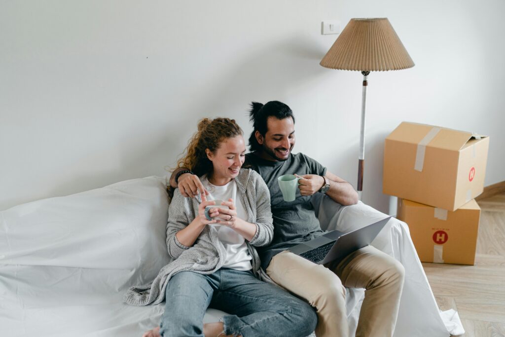 a couple drinking coffee and watching something on their laptop
