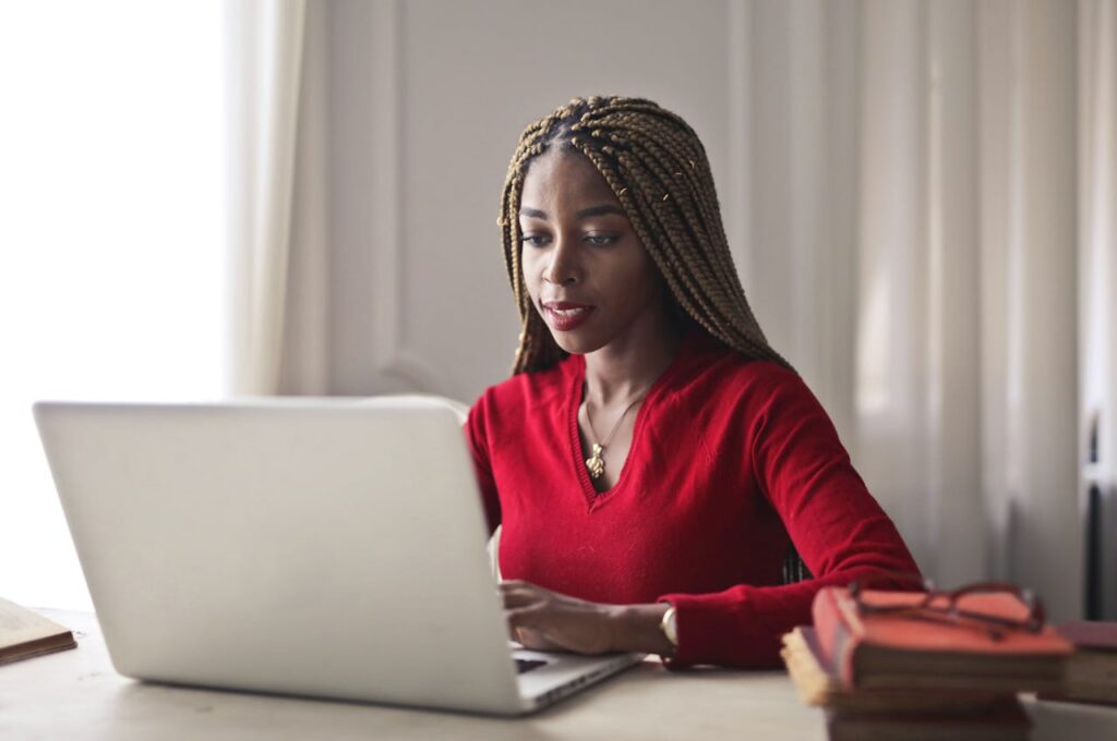 woman in red blouse using her laptop