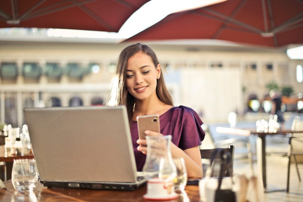 woman using her phone and laptop and reading about shipping a car from Florida to South Carolina