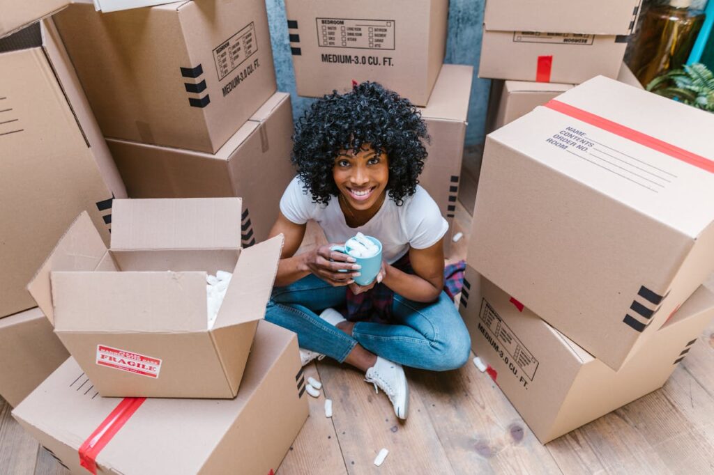 woman smiling while sitting among boxes