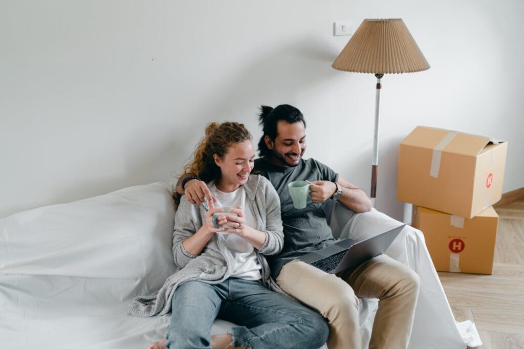 man and woman sitting and looking at their laptop while drinking coffee