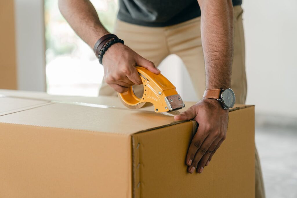 man taping a box
