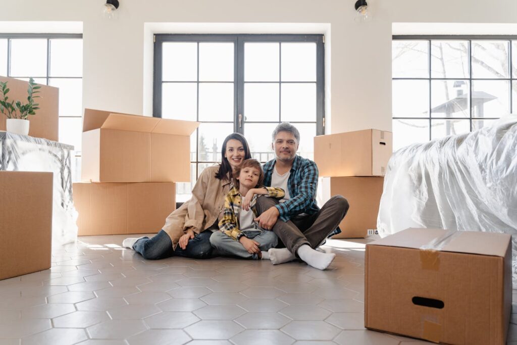 family of three sitting among boxes before making post-moving checklist