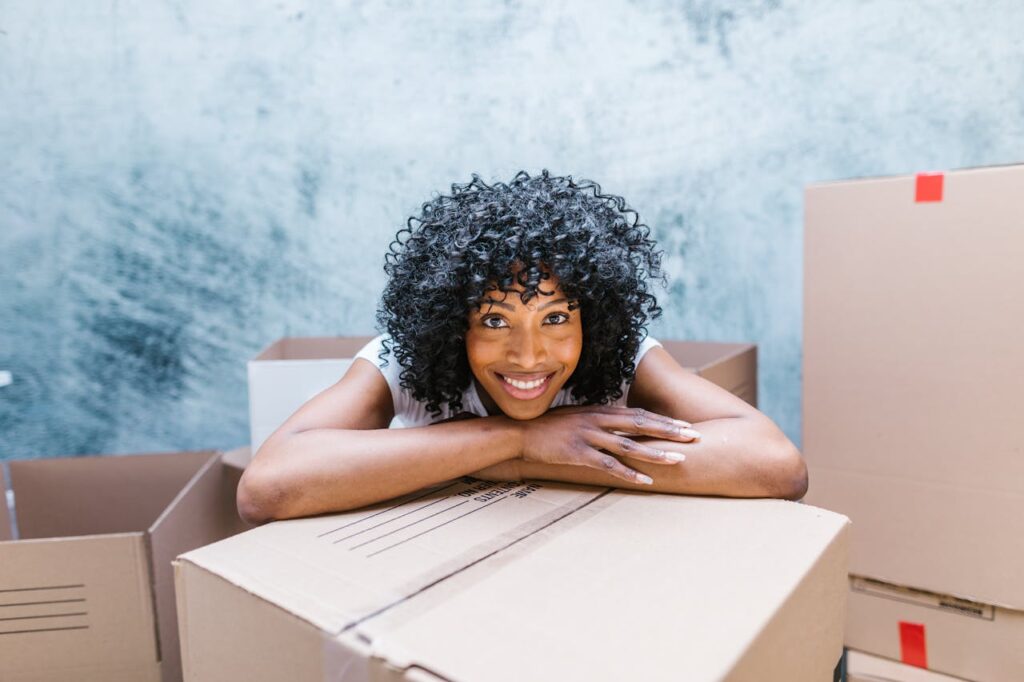woman smiling and leaning on a box