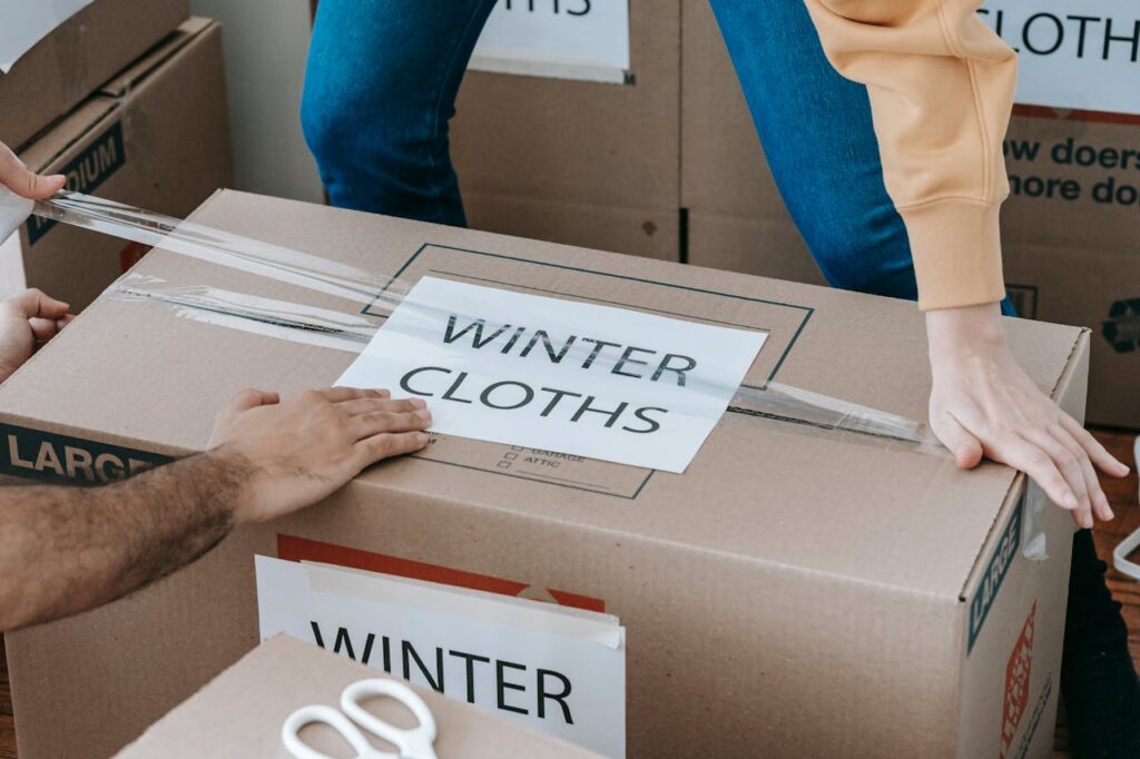 Woman Closing Up A Box With Adhesive Tape
