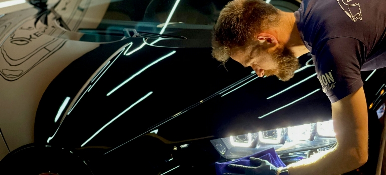 A man is cleaning his car before shipping it from Indiana to Florida. 