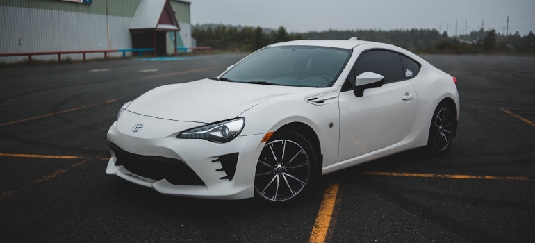 An elegant white car is parked. 