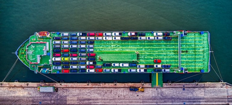 Green cargo boat beside dock. 
