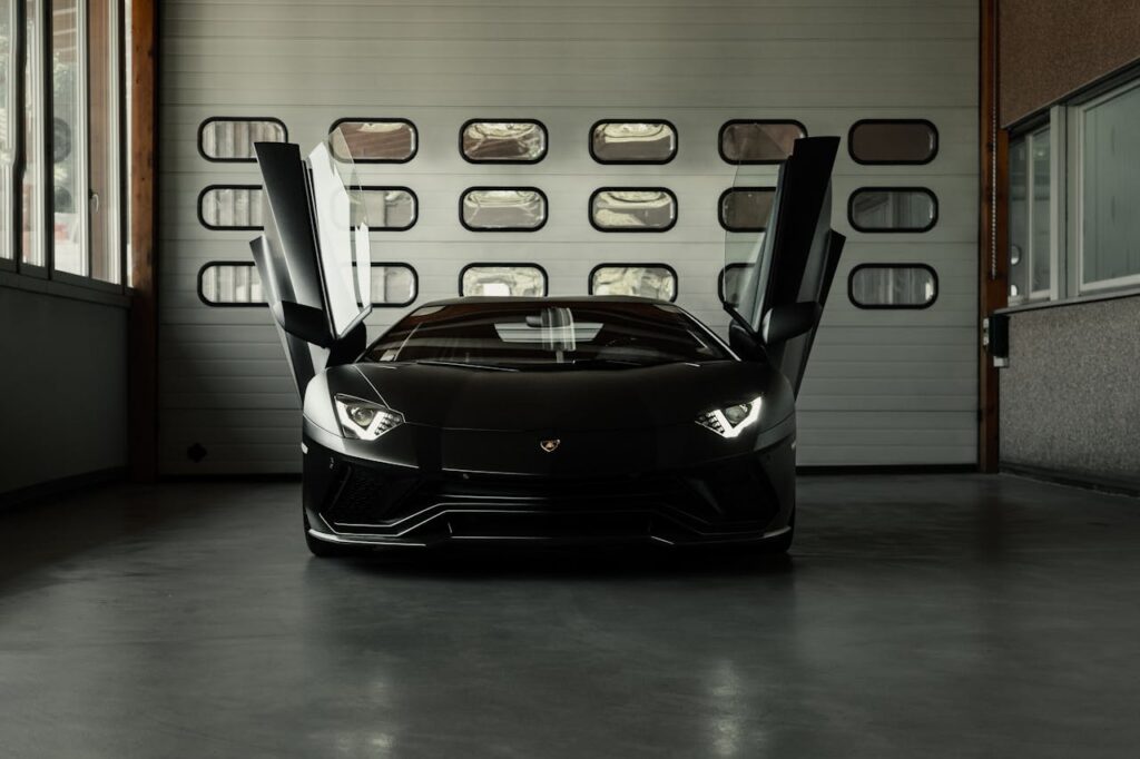 Luxury Black Car with Open Doors in Garage
