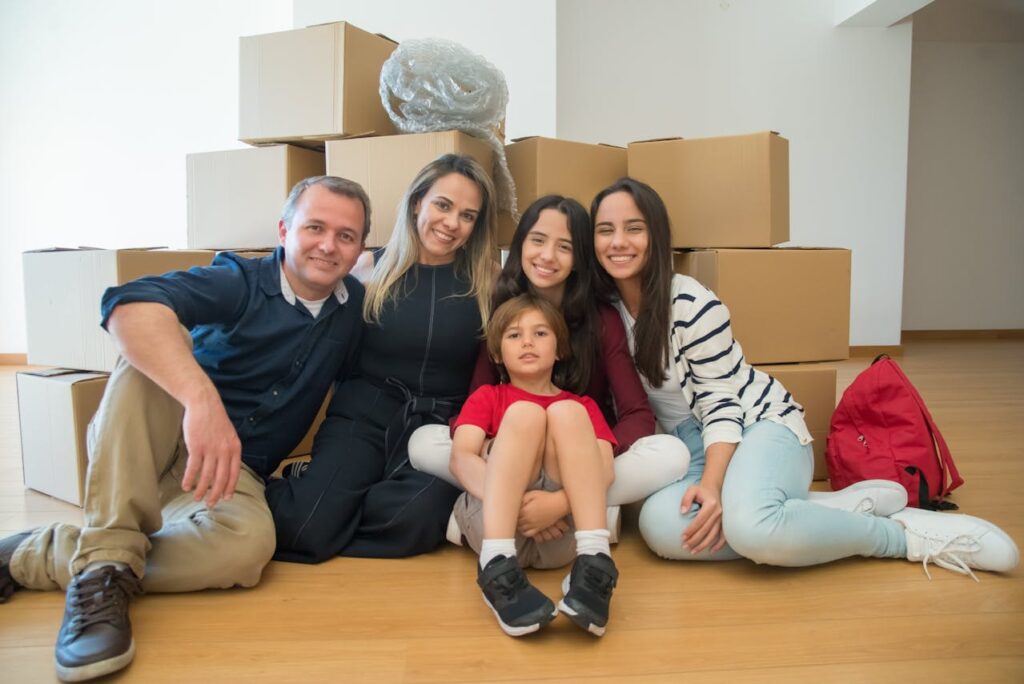 family sitting on floor among boxes