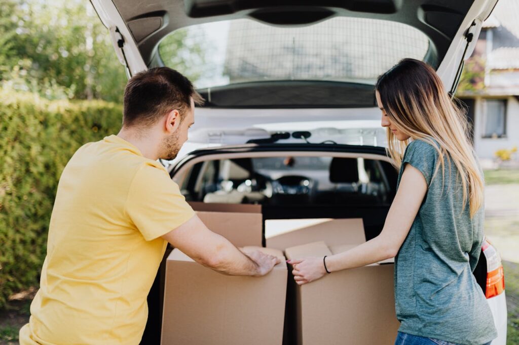 man and woman putting boxes into their car
