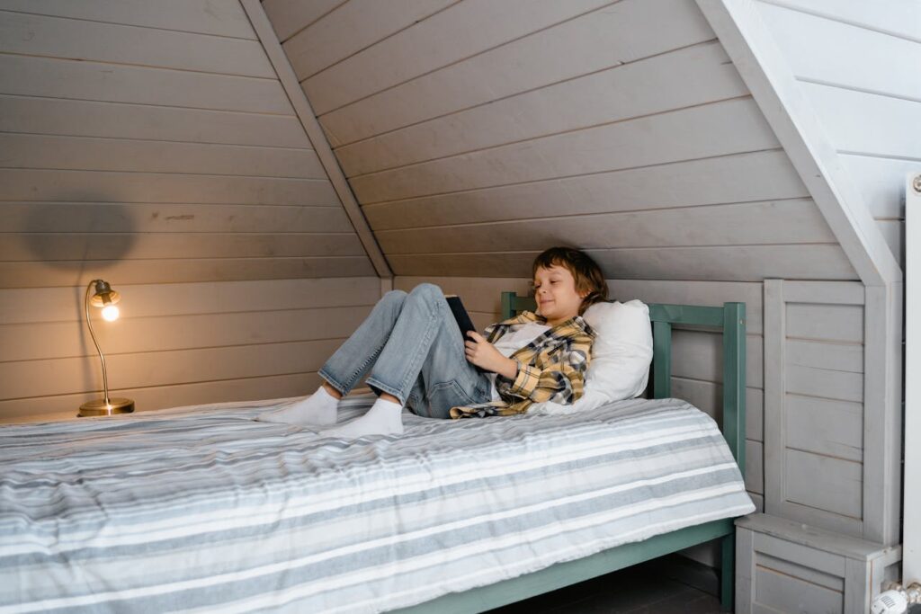 Boy in Yellow and Black Plaid Shirt Lying on Bed

