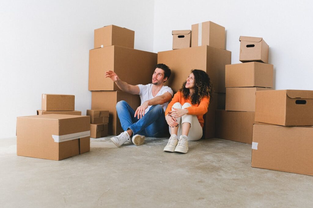 man and woman sitting near boxes