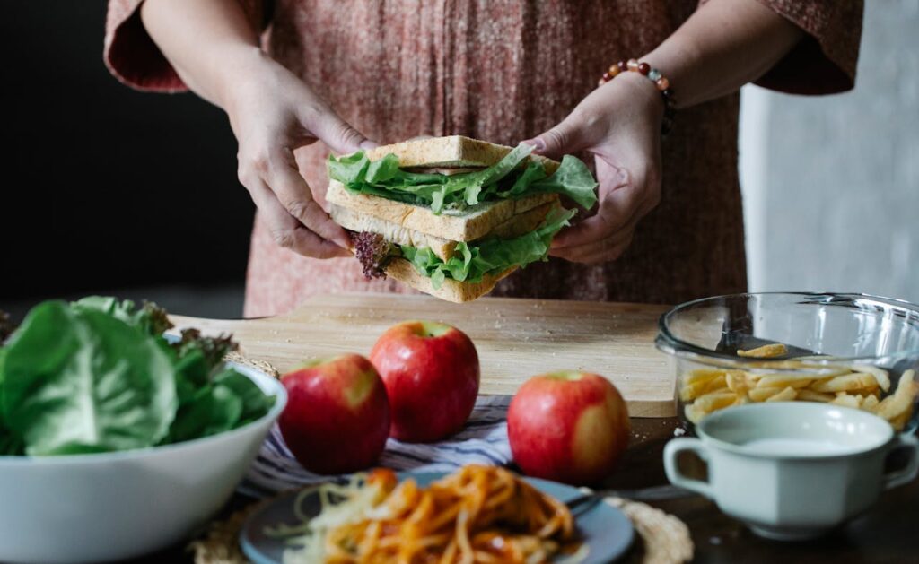 Crop woman with sandwich in hands