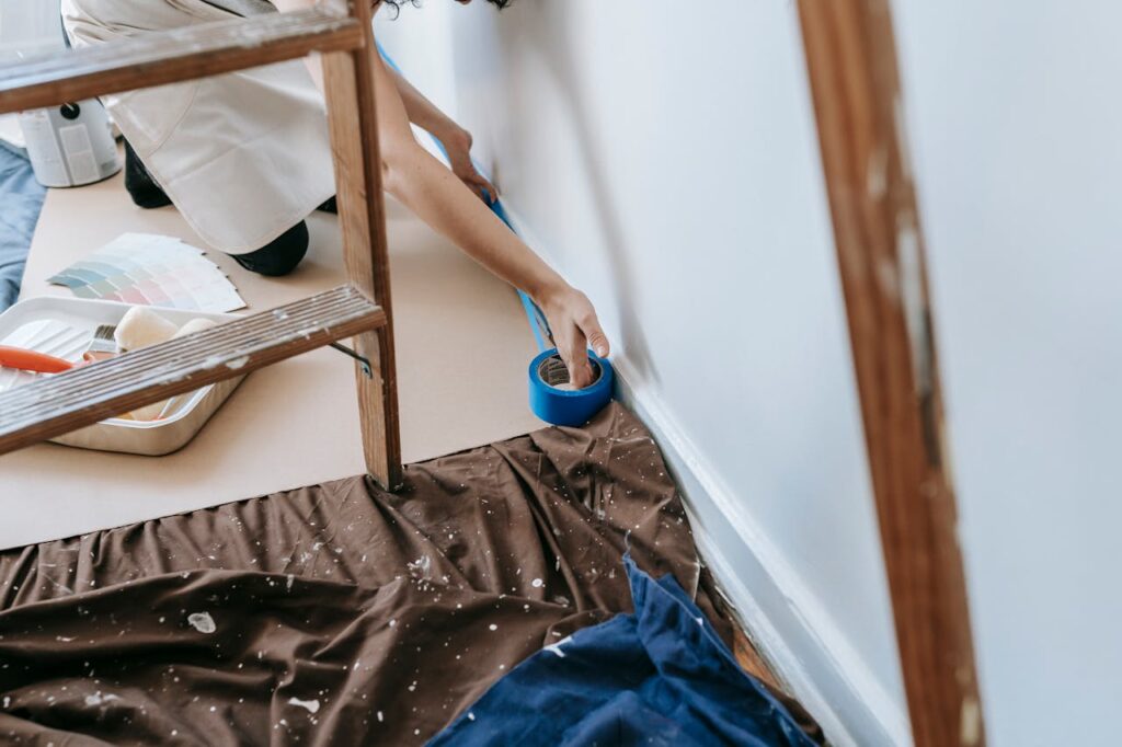 Crop Photo Of Person Putting Tape On Wall

