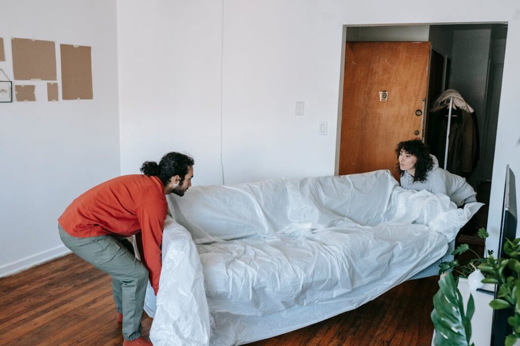 A Couple Lifting A Couch
