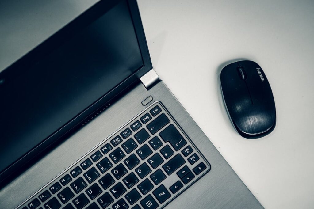 Opened Silver Laptop and Black Computer Mouse
